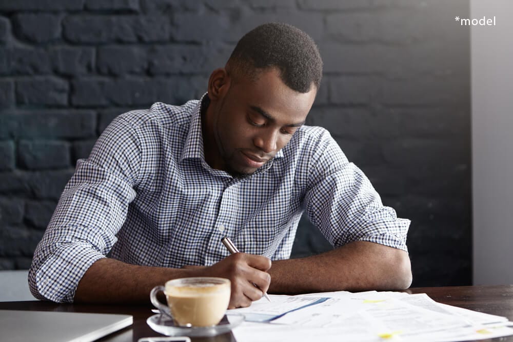 Young man filling out paperwork.