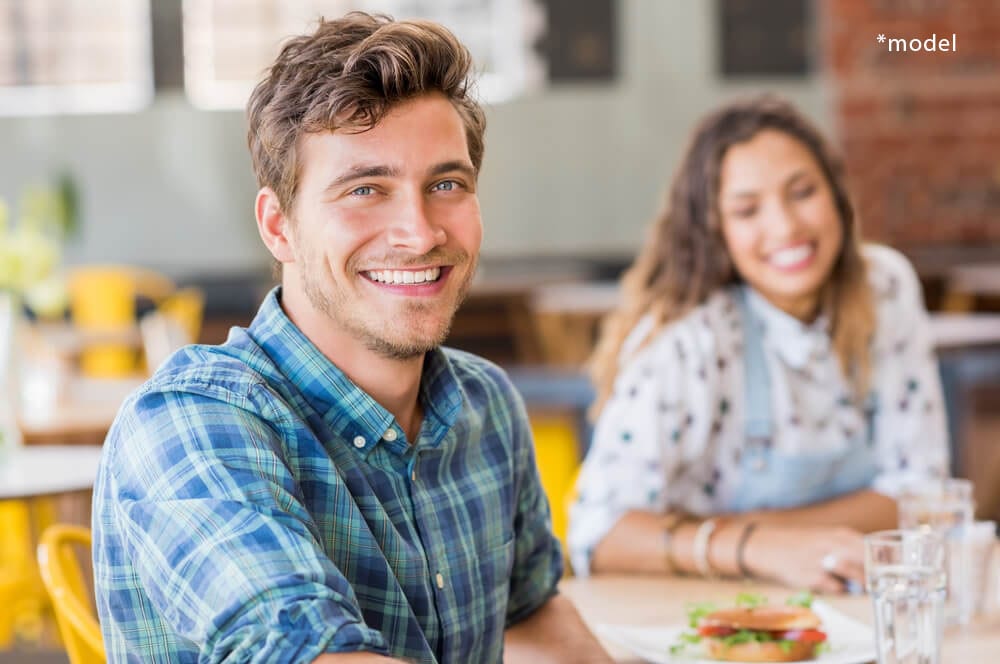 Young man and woman smiling at camera.