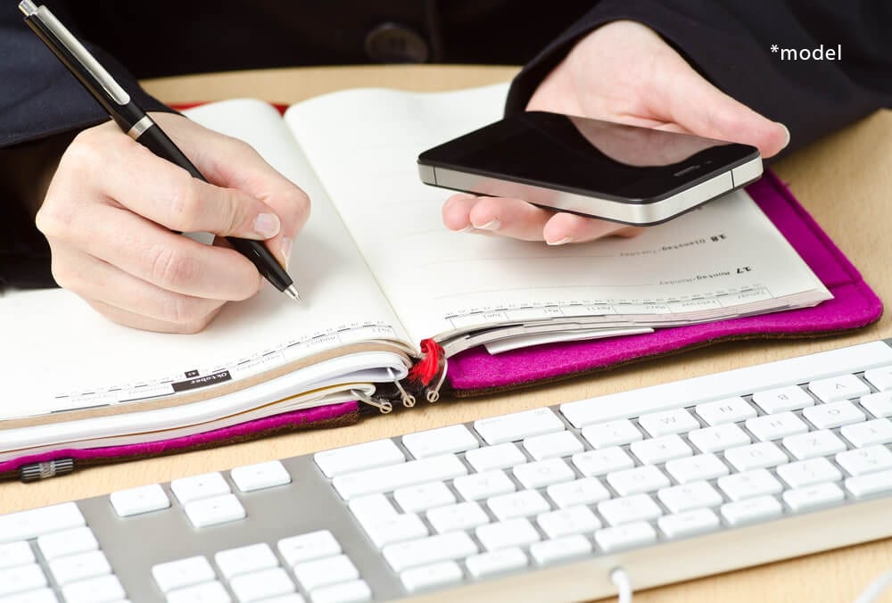 Woman writing in planner.