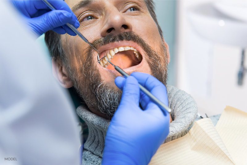 Man in the dentist chair getting his teeth checked