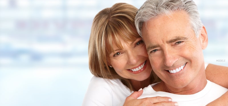 Smiling middle-aged couple with healthy teeth.