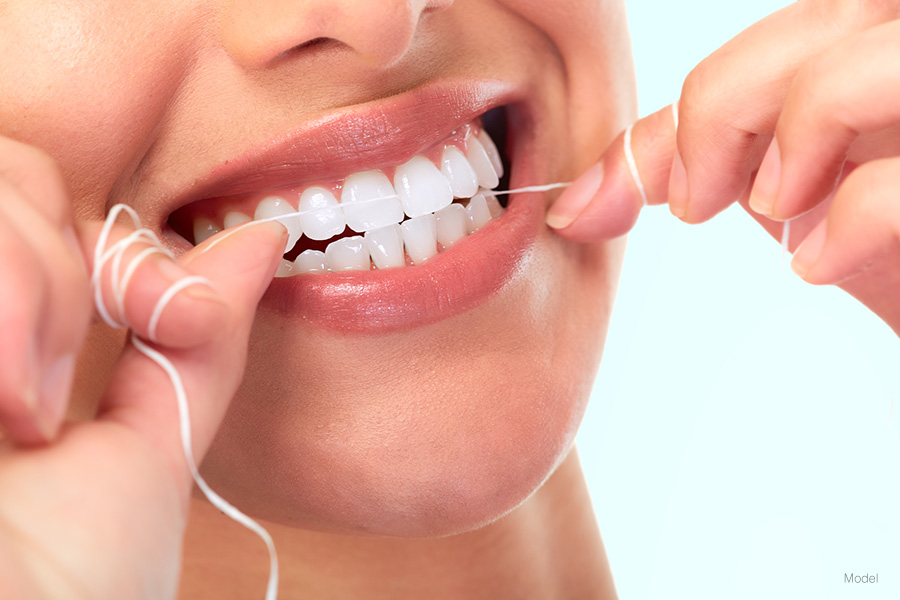 Woman flossing her teeth