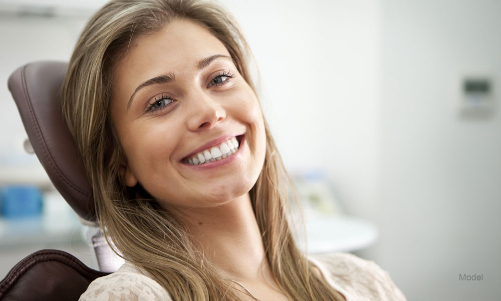 Woman sitting in a dental office smiling